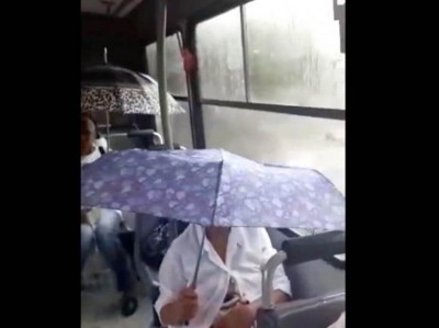 Passageiros abrem guarda-chuvas dentro de coletivo para se proteger de goteiras (Foto: Reprodução/ Facebook)