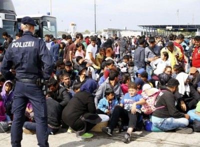 Migrantes aguardam para embarcar em ônibus em Nickelsdorf, na Áustria, nesta segunda-feira (14); cidade fica n... ()