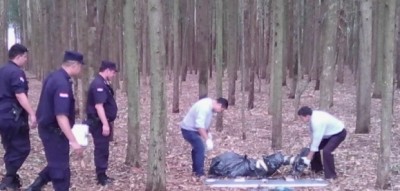 Policiais paraguaios recolhem corpo deixado enrolado dentro de saco plástico numa mata em Pedro Juan (Leo Veras)