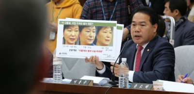 Deputado oposicionista Lee Yong-joo, do Partido do Povo, mostra montagem com fotos da presidente afastada Park... (Ahn Young-Joon/ AFP)