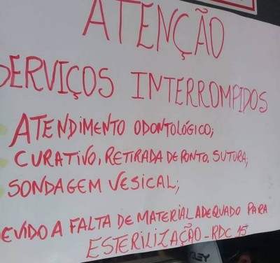 Cartaz informa serviços interrompidos por falta de material de saúde (Foto: divulgação/94FM)