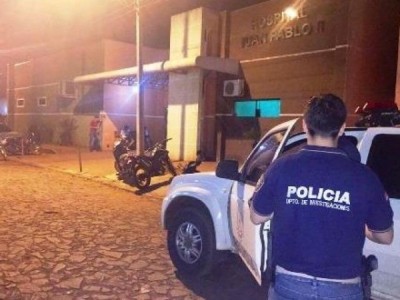Policial na frente do hospital para onde a vítima foi levada. (Foto: Porã News)