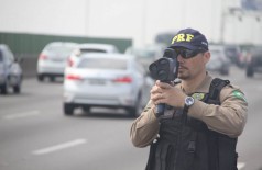 Policial monitorando a velocidade de veículos em rodovia. (Foto: Divulgação/PRF/ReproduçãoAgênciaBrasil)
