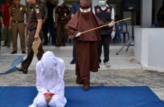 Açoitadora se prepara para punir criminosa sexual na Indonésia - Foto: AFP
