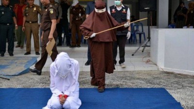 Açoitadora se prepara para punir criminosa sexual na Indonésia - Foto: AFP