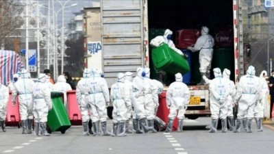 Agentes recolhem latas de lixo no mercado de Huanan, em Wuhan Agentes recolhem latas de lixo no mercado de Huanan, em Wuhan - Foto: Reuters