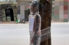 Jovem é amarrado a árvore com filme plástico após não pagar por tatuagem - Foto: Reprodução