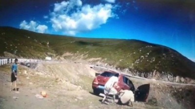 Família para diante de paisagem, mas carro cai em penhasco com uma pessoa a bordo, que sobrevive