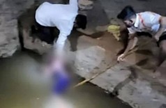 Policiais retiram corpo de criança jogada pela mãe em poço Foto: Reprodução/Extra/Page Not Found