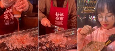 Vendedor ambulante prepara cubos de gelo em churrasqueira em rua na China