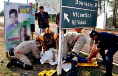 Cavalete protege vítima de sol em acidente, enquanto bombeiros prestam atendimento