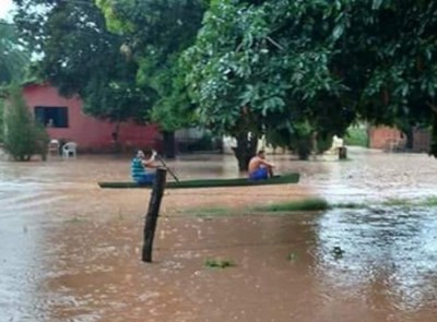 No interior, chuva obriga moradores a usarem barco para sair de casa
