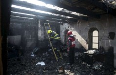 Bombeiros israelenses trabalham em meio aos destroços causados por um incêndio na igreja onde Jesus Cristo fez... (Baz Ratner / Reuters)