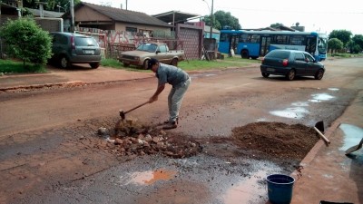Cansado de esperar pela prefeitura, morador de Dourados improvisa tapa-buracos em rua