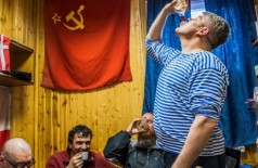 Pesquisadores russos e chilenos bebem vodca caseira em estação na Antártida (Daniel Berehulak/The New York Times)